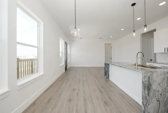 a view of a kitchen with a sink and wooden floor