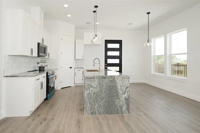 a kitchen with kitchen island white cabinets and white appliances