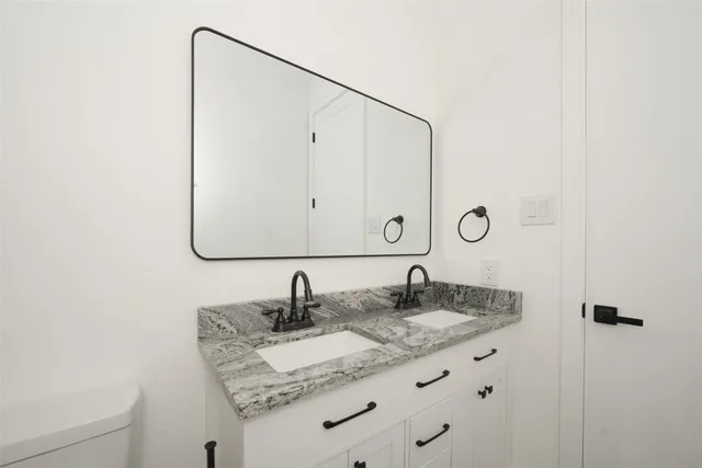 a bathroom with a granite countertop sink and a mirror