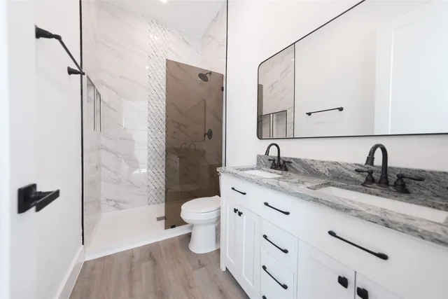 a bathroom with a granite countertop sink toilet and shower