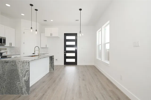 a large kitchen with kitchen island a sink stainless steel appliances and a window