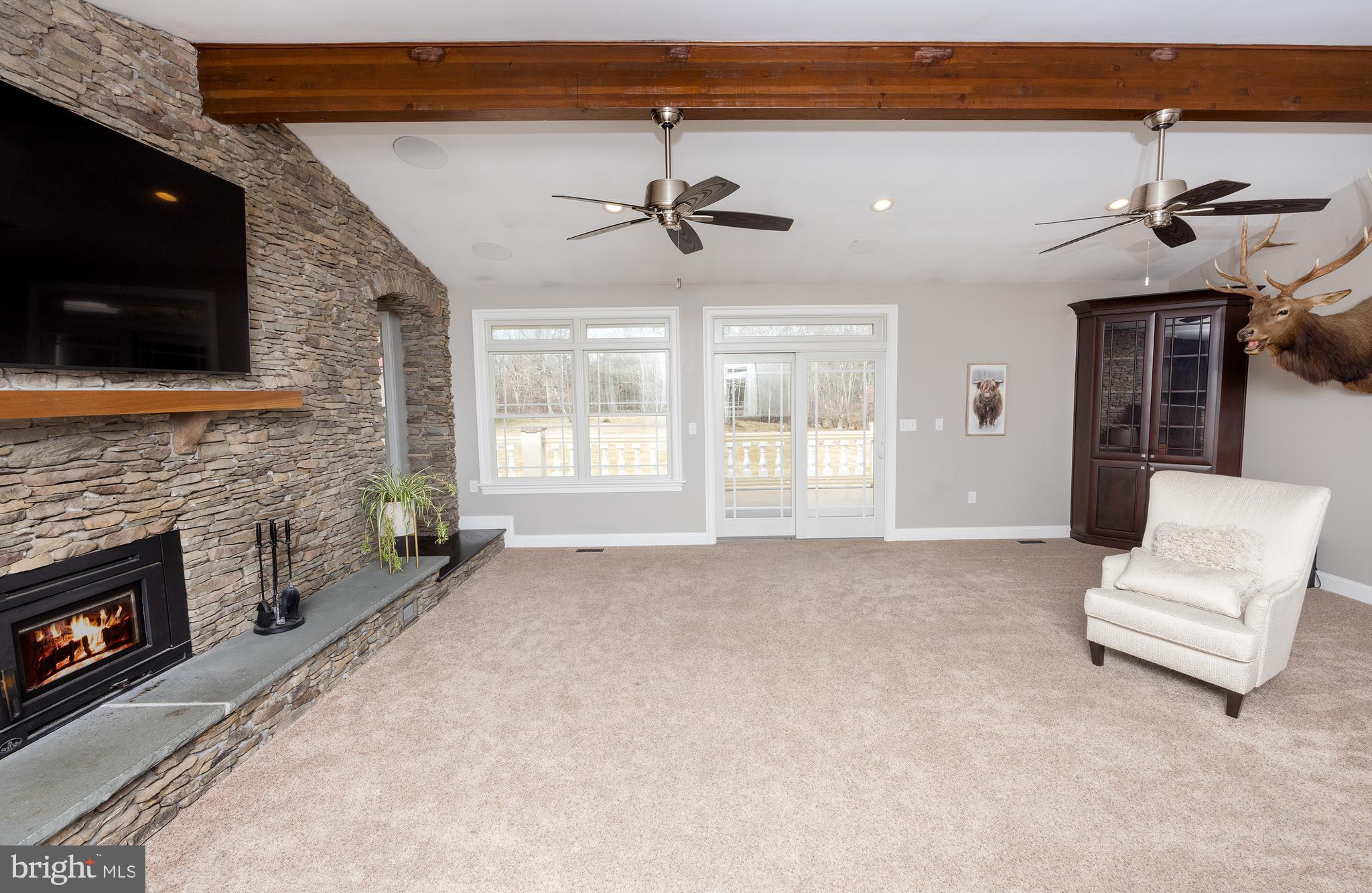 6469 Groveland Road Pipersville, PA 18947 - Photo 11 of 53 a living room with furniture a flat screen tv and a fireplace