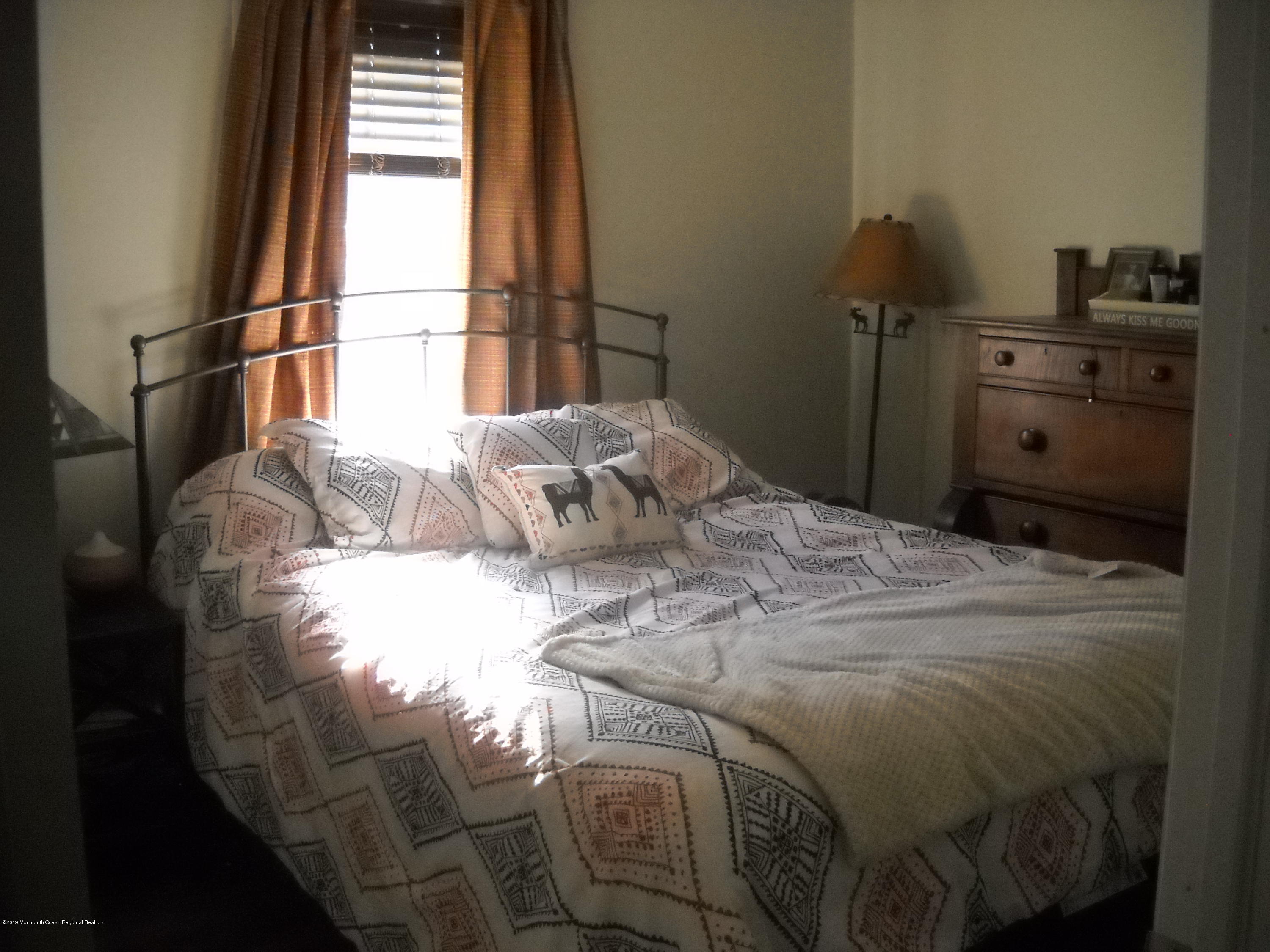 32 Hornerstown Road Cream Ridge, NJ 08514 - Photo 17 of 19 a bed sitting in a bedroom next to a window