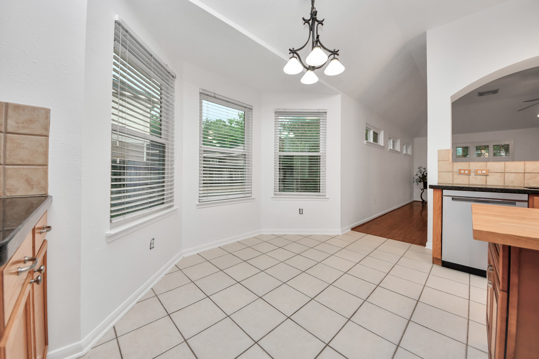 5622 Pineaster Pointe Lane Spring, TX 77379 - Photo 15 of 40 Tile flooring in a breakfast nook with natural wood cabinetry and a black countertop