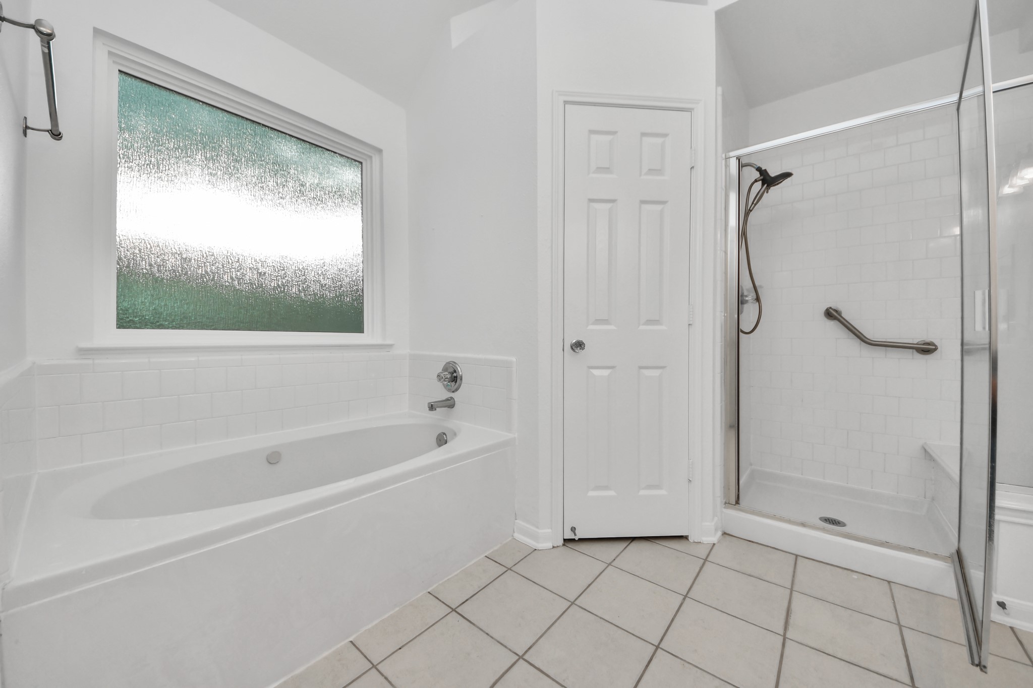 5622 Pineaster Pointe Lane Spring, TX 77379 - Photo 24 of 40 Bathroom featuring a built-in tub with tile surround, a separate glass-enclosed shower with subway tile, a shower bench, and a privacy window