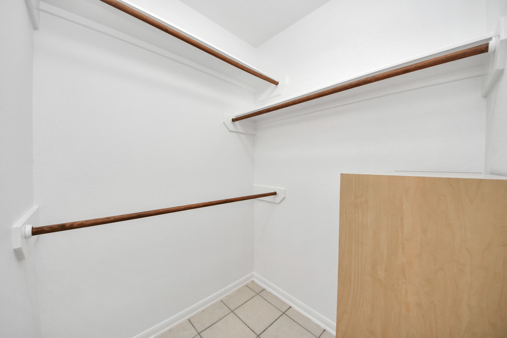 5622 Pineaster Pointe Lane Spring, TX 77379 - Photo 25 of 40 Walk-in closet featuring white walls, three wood-finish hanging rods, and light-toned floor tiles