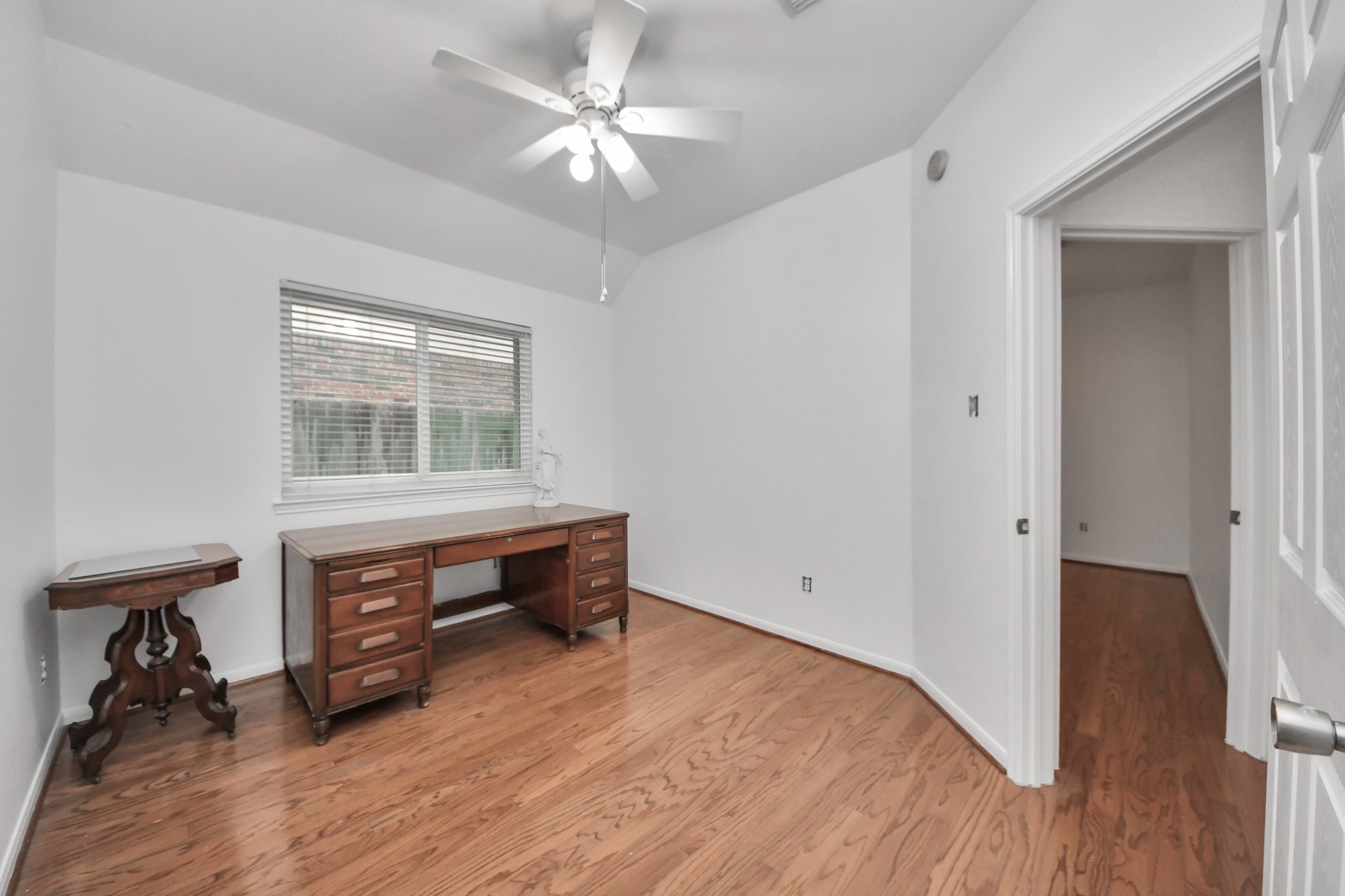 5622 Pineaster Pointe Lane Spring, TX 77379 - Photo 27 of 40 Hardwood-finish flooring throughout, featuring a window with horizontal blinds, white ceiling fan, and baseboard molding