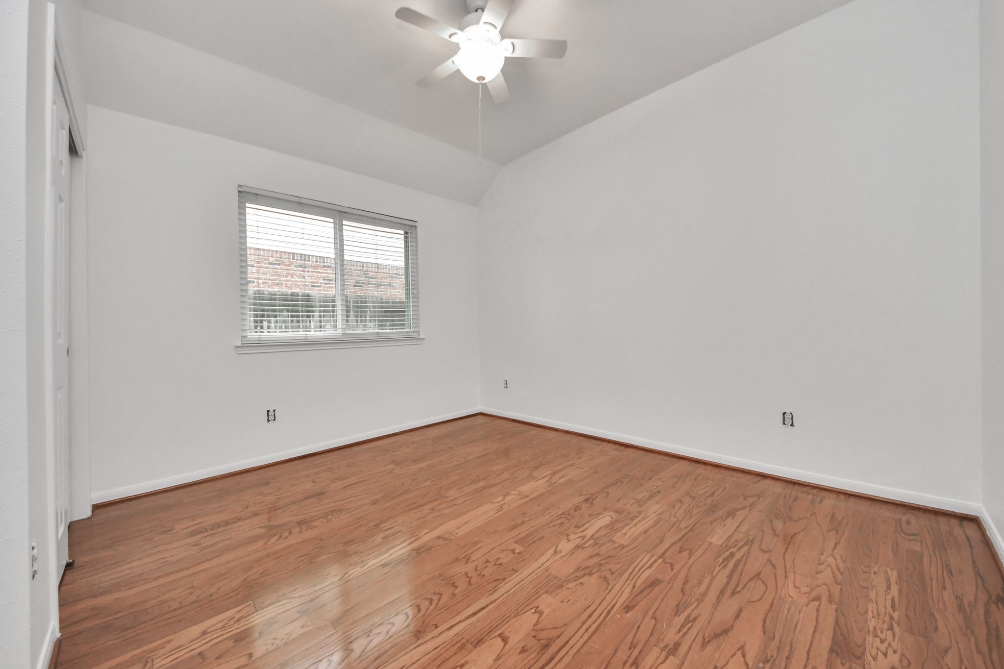 5622 Pineaster Pointe Lane Spring, TX 77379 - Photo 28 of 40 Room featuring wood-finish flooring, a window with horizontal blinds, and a white ceiling fan