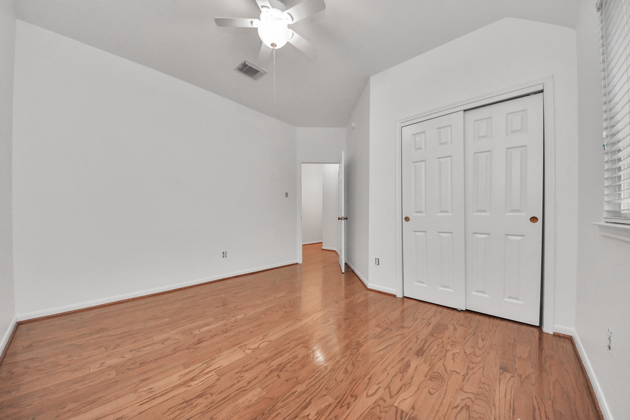 5622 Pineaster Pointe Lane Spring, TX 77379 - Photo 30 of 40 Spacious room featuring wood-finish flooring, white walls, and a ceiling fan with integrated lighting