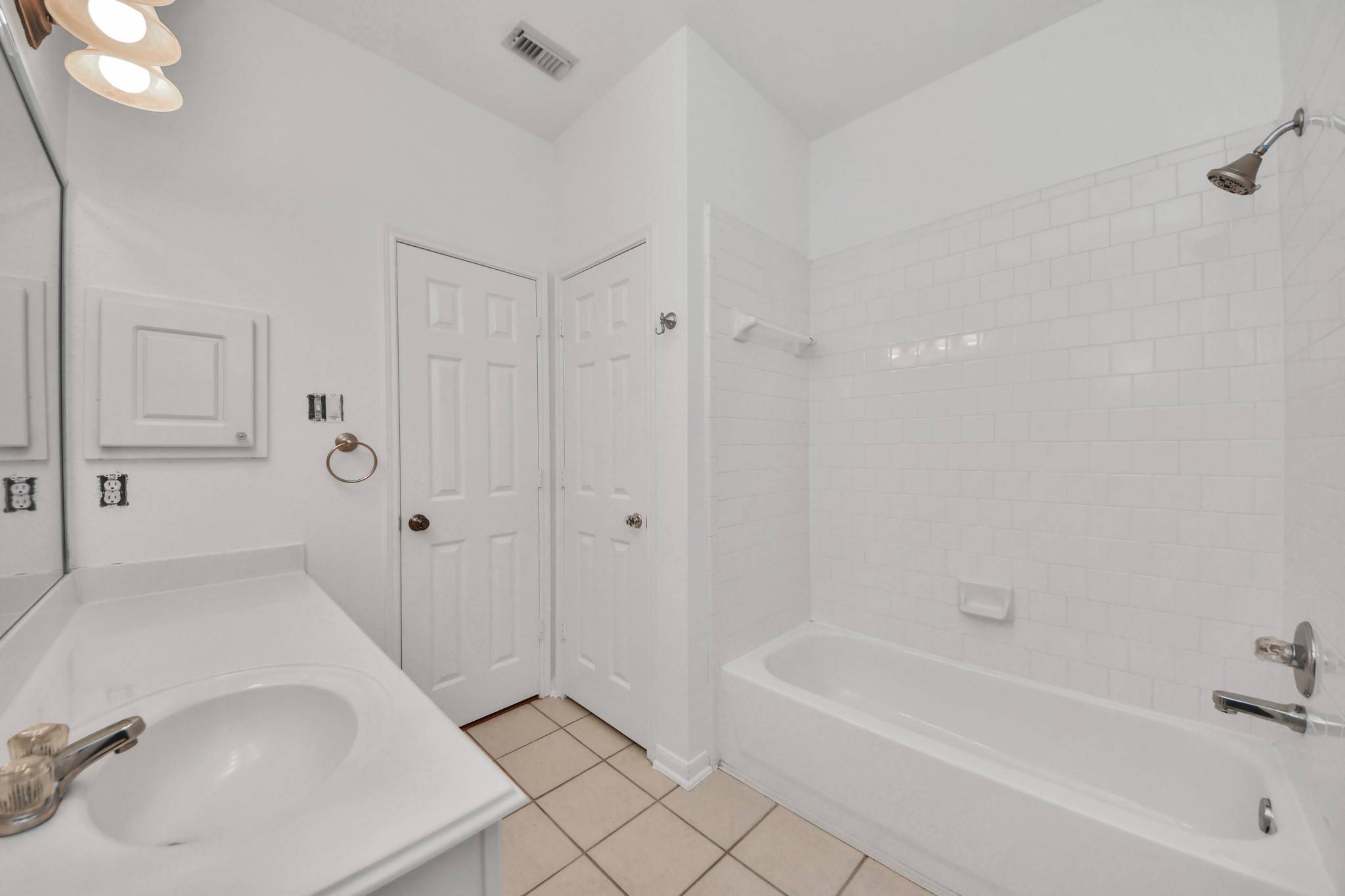 5622 Pineaster Pointe Lane Spring, TX 77379 - Photo 32 of 40 White bathroom featuring a single vanity, integrated sink, and a combination tub/shower with subway tile surround