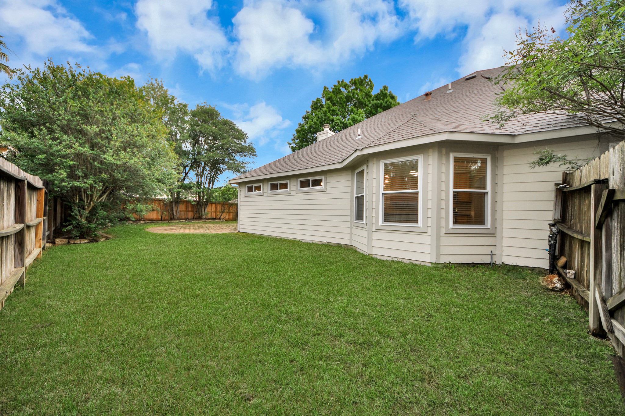 5622 Pineaster Pointe Lane Spring, TX 77379 - Photo 34 of 40 Expansive backyard featuring a manicured lawn, established trees, full privacy fencing, and a bay window extension