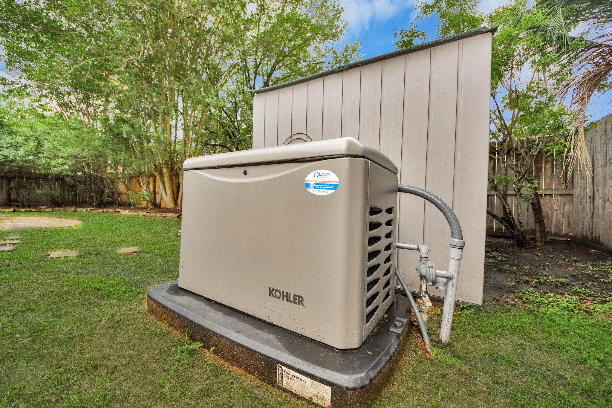 5622 Pineaster Pointe Lane Spring, TX 77379 - Photo 37 of 40 Kohler whole-house generator on a concrete pad, positioned beside a utility shed