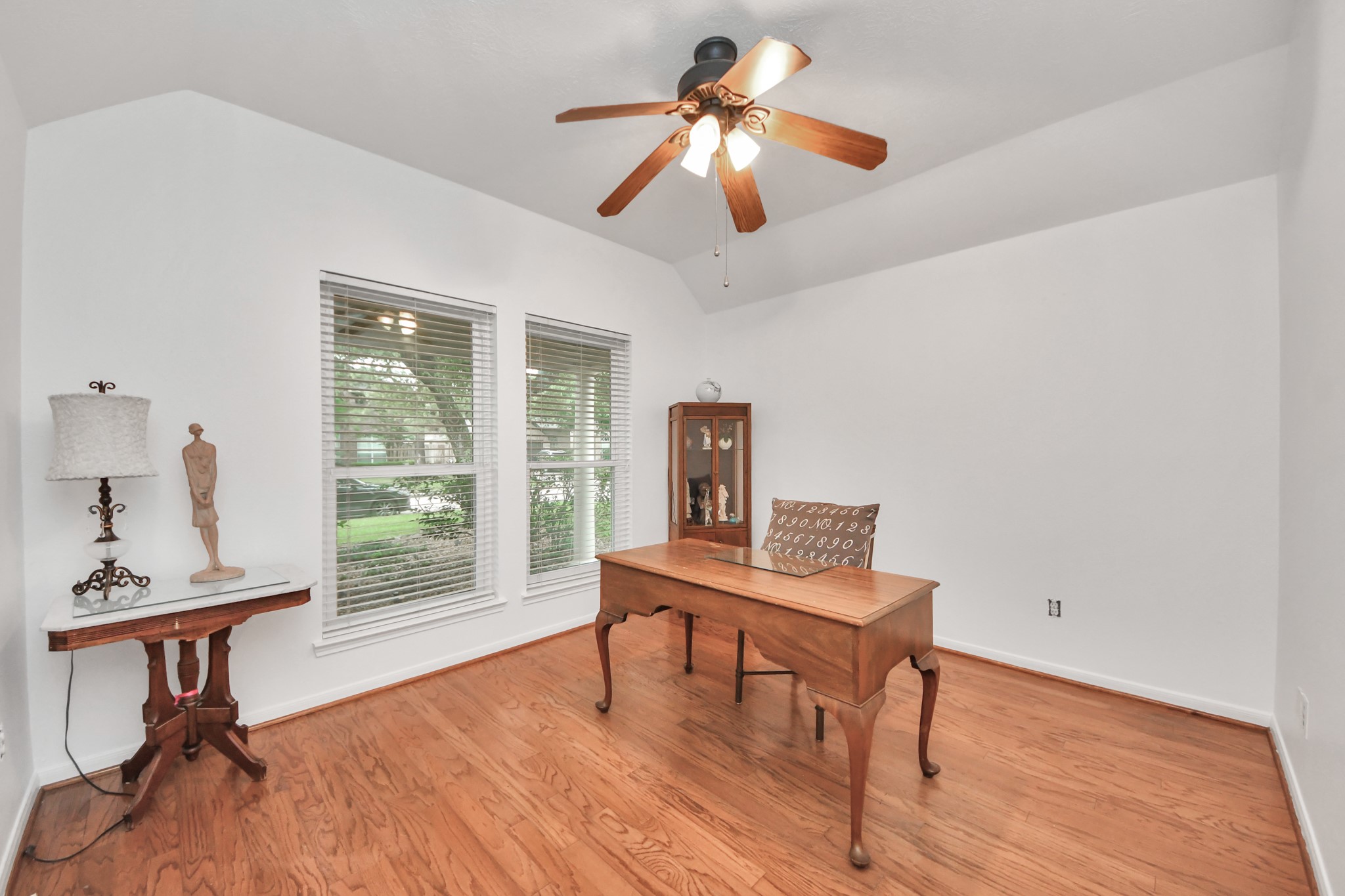 5622 Pineaster Pointe Lane Spring, TX 77379 - Photo 6 of 40 Vaulted ceilings complement wood-finish flooring in this room featuring two windows with horizontal blinds and a ceiling fan with integrated lighting