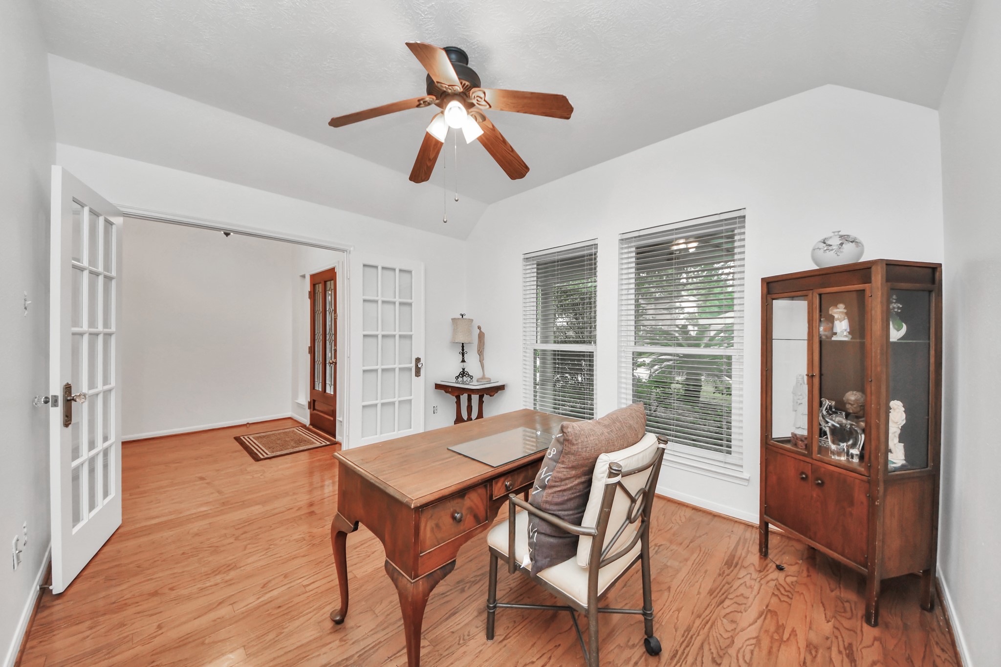 5622 Pineaster Pointe Lane Spring, TX 77379 - Photo 7 of 40 Interior space featuring wood-finish flooring, two large windows with blinds, a ceiling fan with integrated lighting, and white French doors