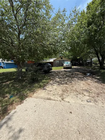 a view of a yard with wooden fence