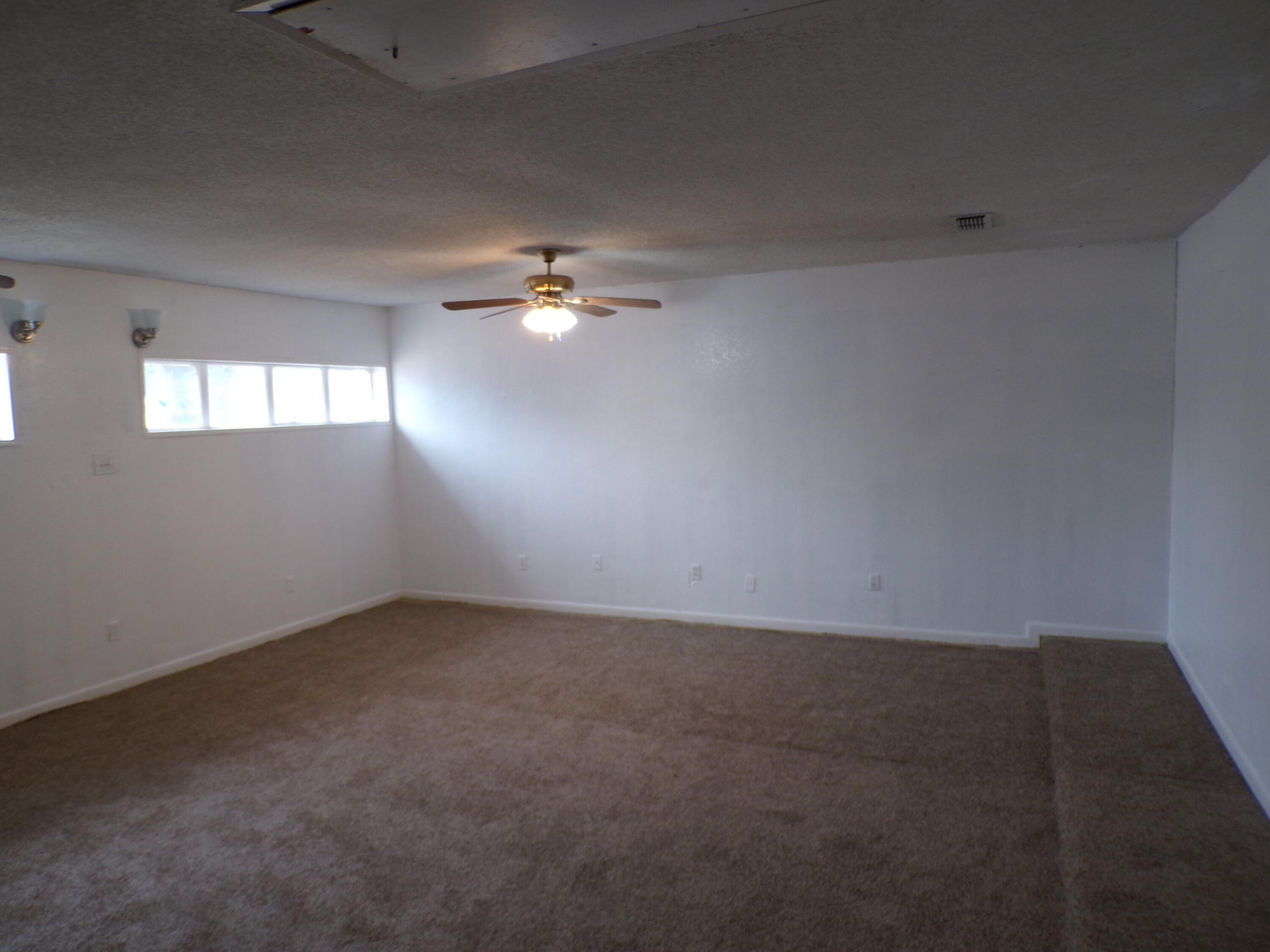 5916 14th Street Lubbock, TX 79416 - Photo 20 of 22 en empty room with windows and chandelier fan