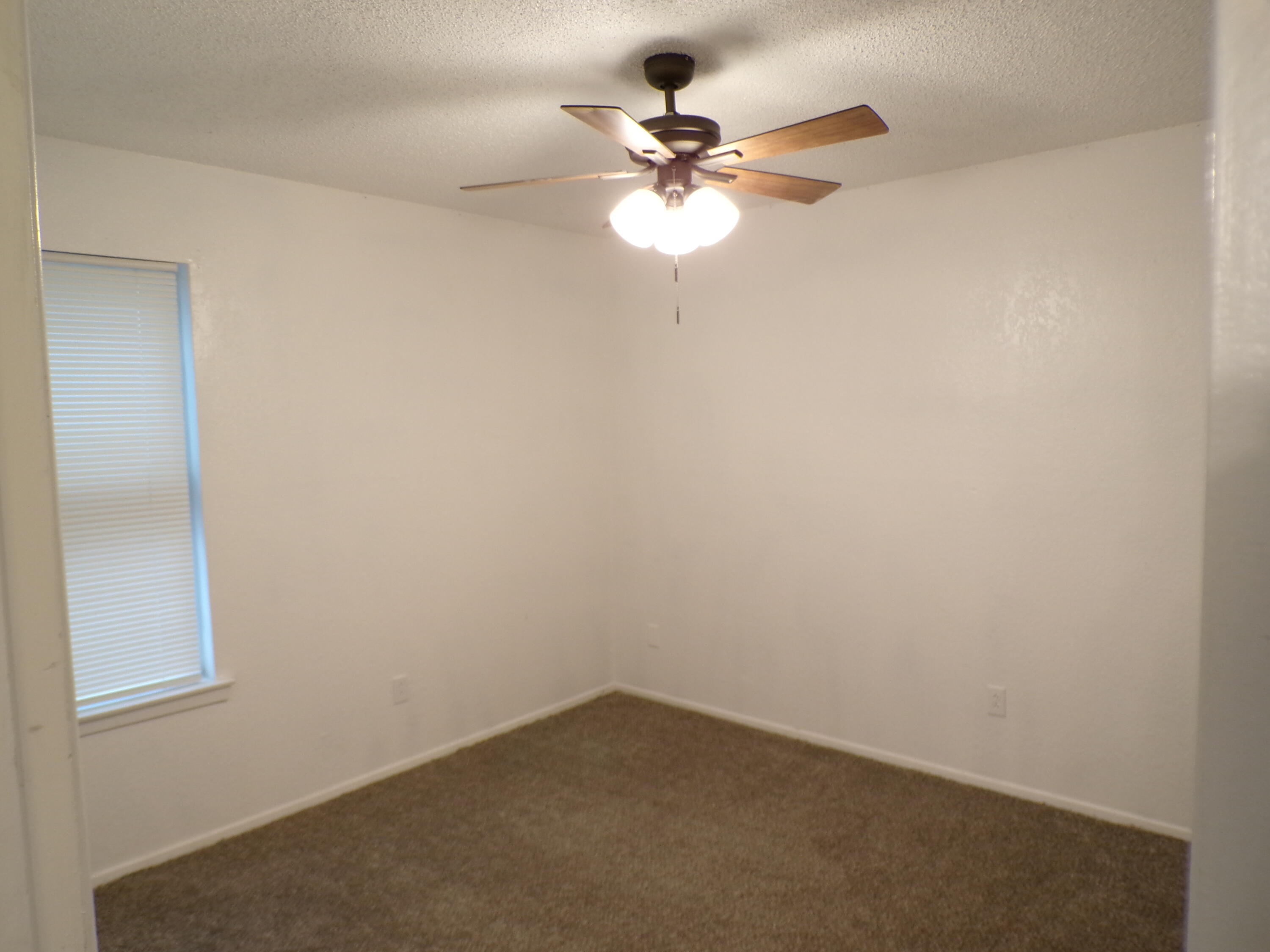 5916 14th Street Lubbock, TX 79416 - Photo 4 of 22 an empty room with a window and a fan