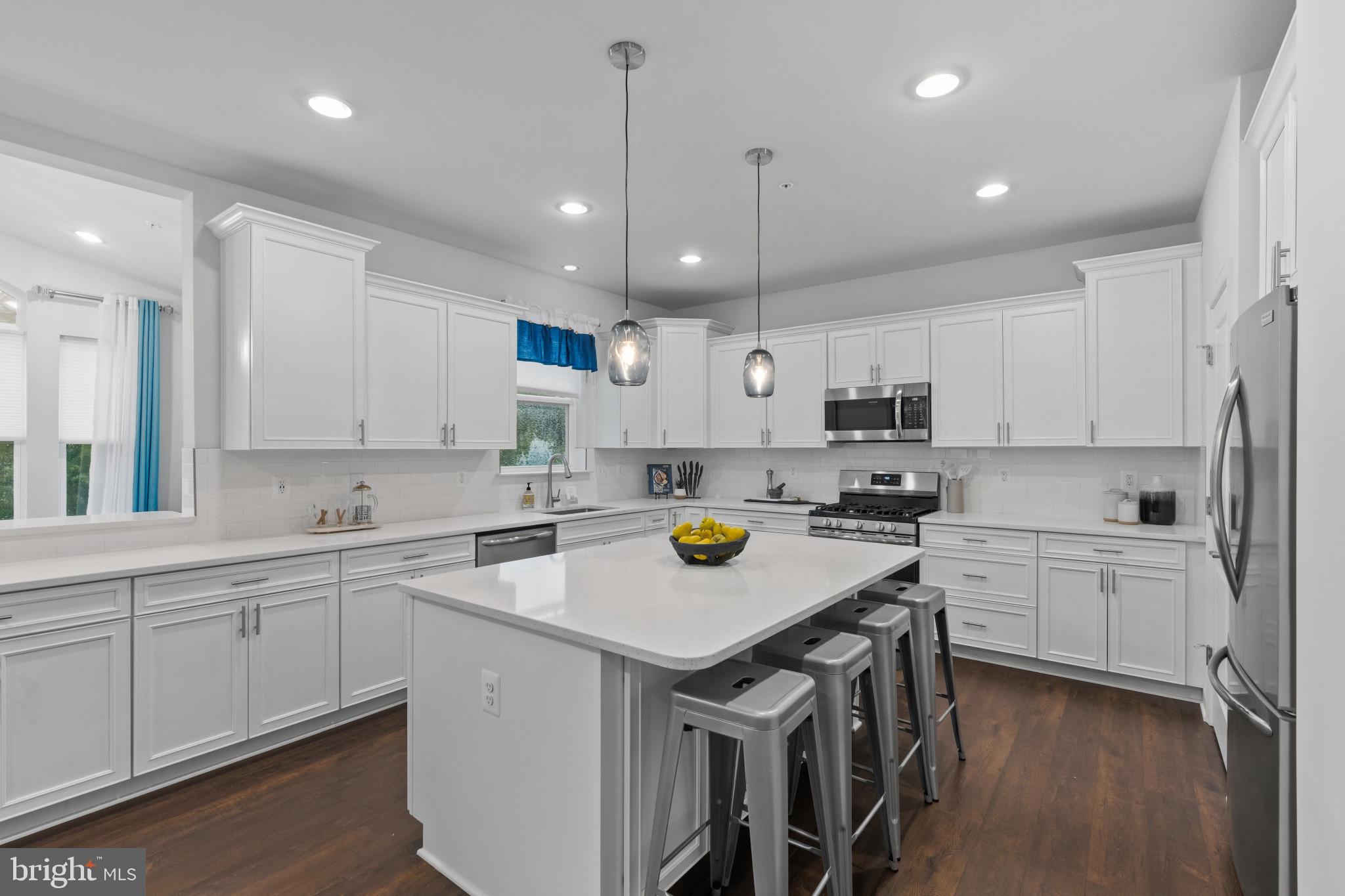 703 Perception Way Aberdeen, MD 21001 - Photo 6 of 42 a kitchen with a stove a sink a center island and cabinets
