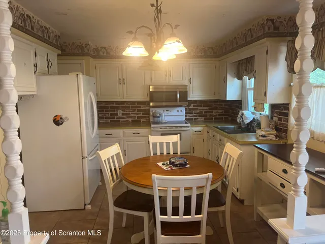 a kitchen with stainless steel appliances a dining table chairs and granite counter tops