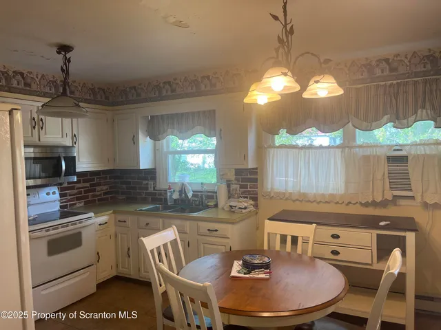 a kitchen with a stove a sink a dining table and chairs
