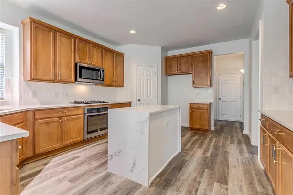 a kitchen with granite countertop a stove top oven and sink