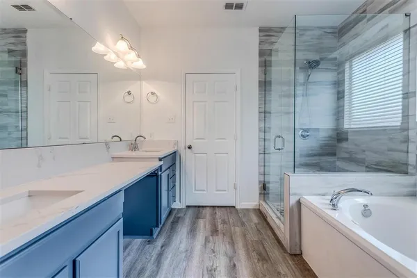 a bathroom with a tub a sink shower and mirror