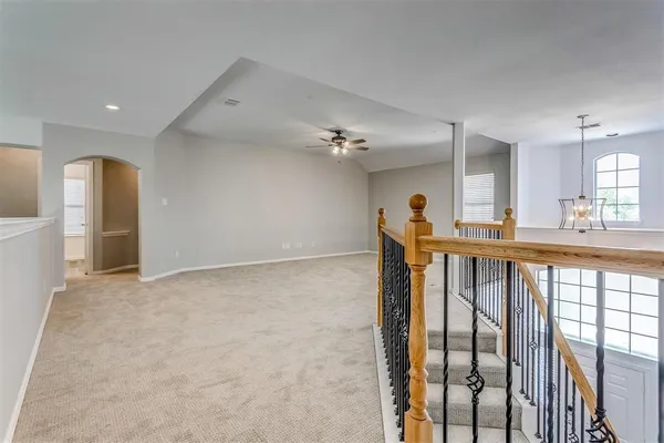 an empty room with a ceiling fan and windows