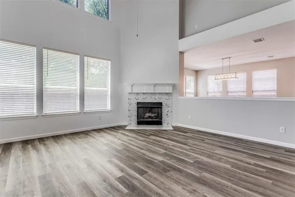 a view of an empty room with a window and fireplace