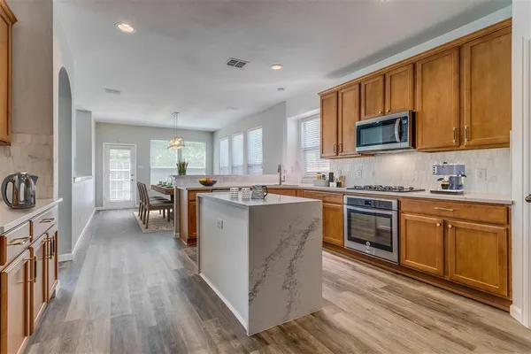 a kitchen with wooden floors and wooden cabinets