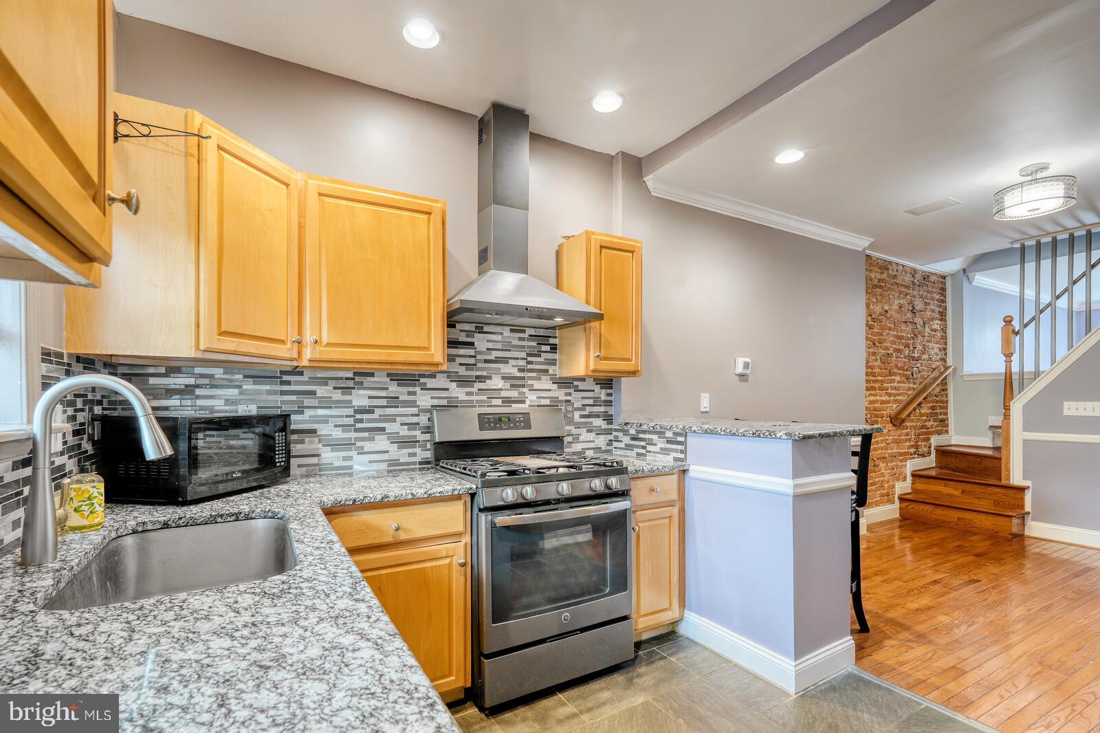 1212 Marshall Street Baltimore, MD 21230 - Photo 11 of 39 a kitchen with stainless steel appliances granite countertop a stove a sink and a microwave