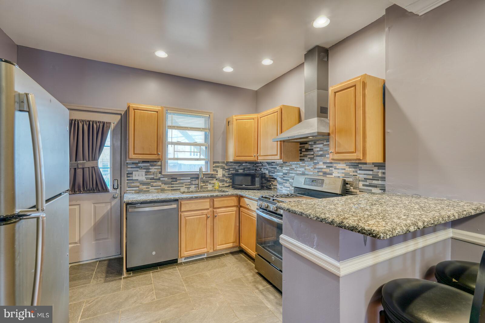 1212 Marshall Street Baltimore, MD 21230 - Photo 12 of 39 a kitchen with stainless steel appliances granite countertop a sink and a refrigerator