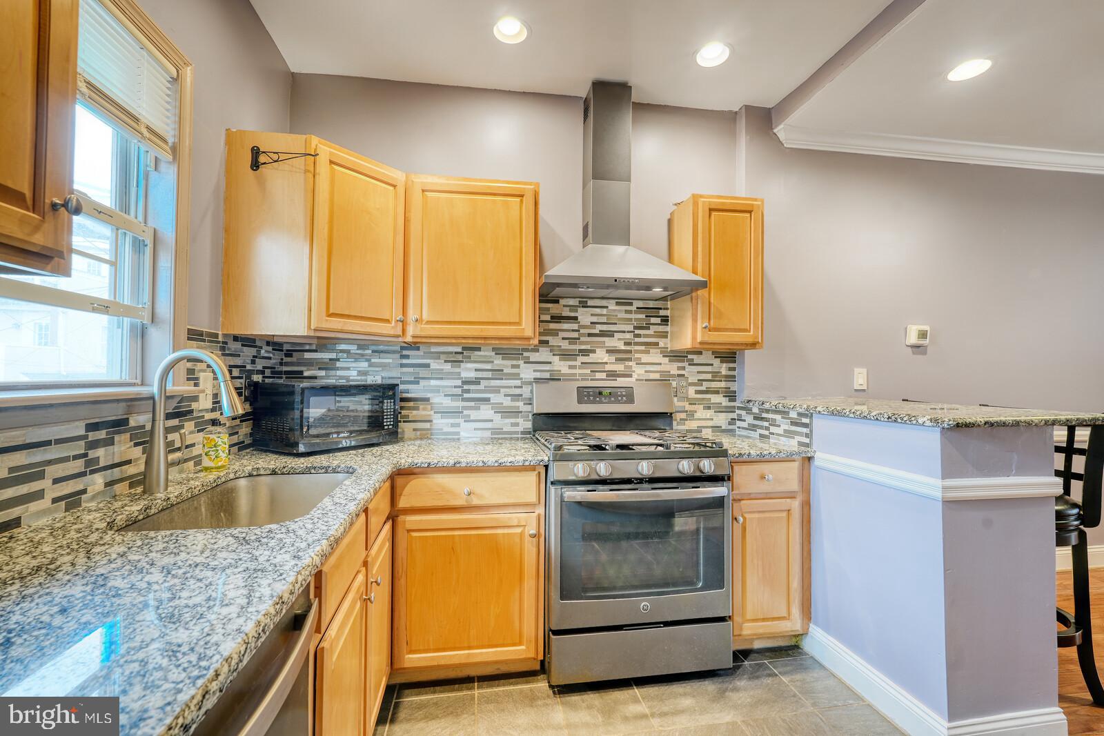 1212 Marshall Street Baltimore, MD 21230 - Photo 14 of 39 a kitchen with stainless steel appliances granite countertop a sink a stove and a wooden cabinets