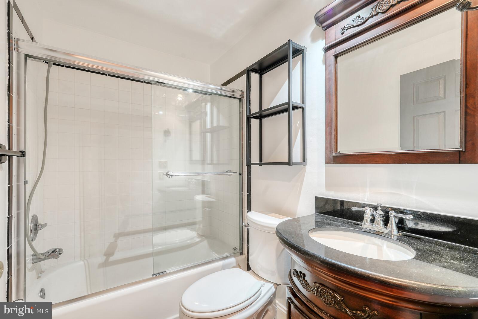 1212 Marshall Street Baltimore, MD 21230 - Photo 19 of 39 a bathroom with a granite countertop sink toilet mirror and shower
