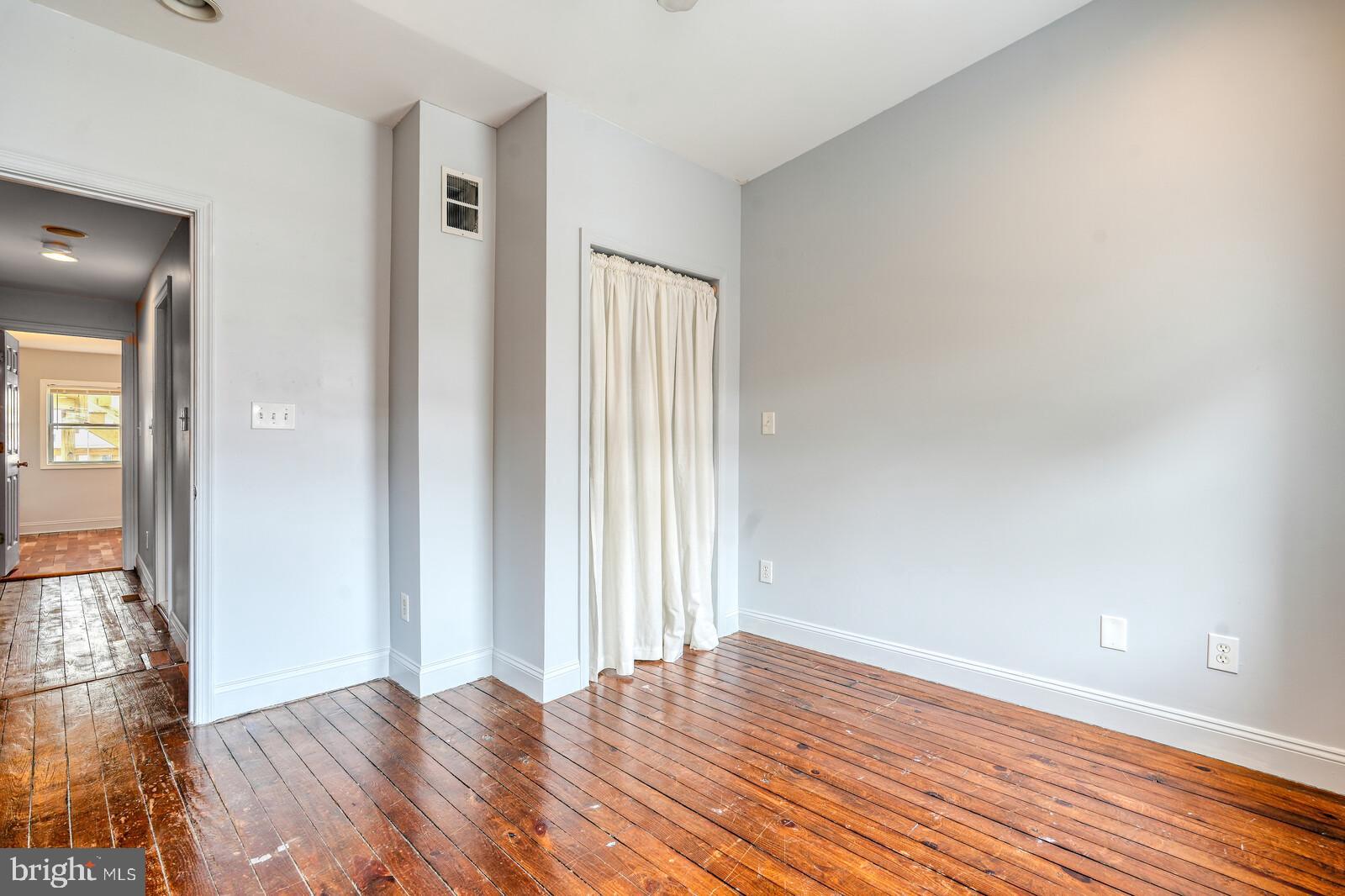 1212 Marshall Street Baltimore, MD 21230 - Photo 23 of 39 an empty room with wooden floor and windows