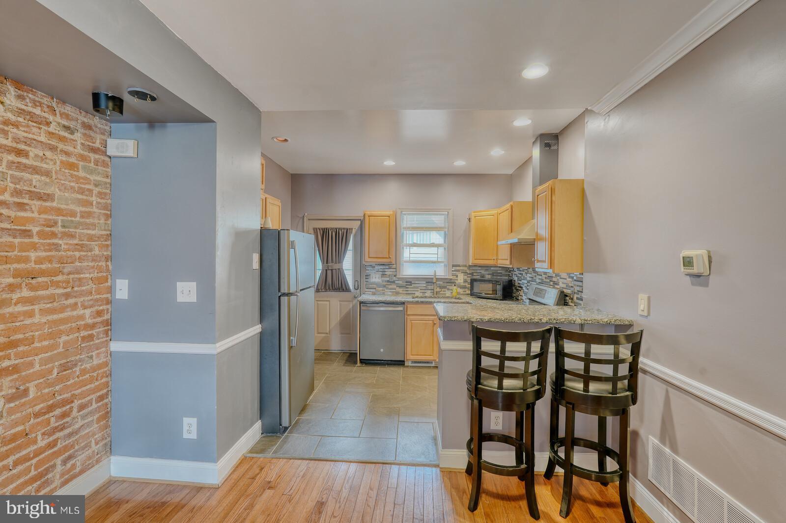 1212 Marshall Street Baltimore, MD 21230 - Photo 10 of 39 a kitchen with a table chairs refrigerator and cabinets