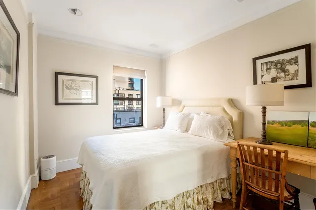 a bedroom with a bed and painting on the wall