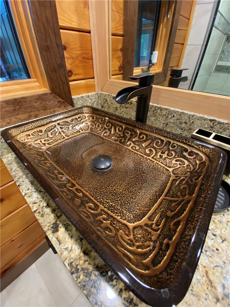 128 McAlister Road West Union, SC 29696 - Photo 20 of 40 An artistic vessel sink with unique patterning enhances this natural wood-accented vanity.