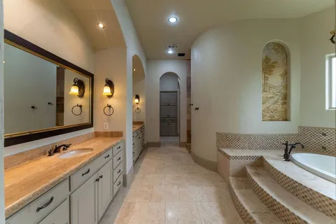 a spacious bathroom with a granite countertop sink and a large mirror