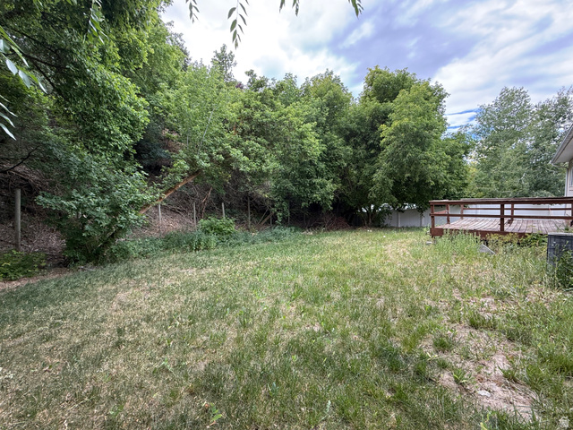 838 East Mountain Road Logan, UT 84321 - Photo 36 of 37 Spacious backyard featuring a wood deck, mature trees, and a partial privacy fence