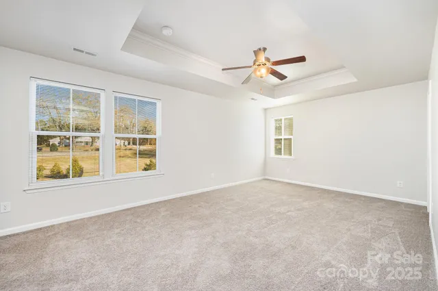 an empty room with windows and fan