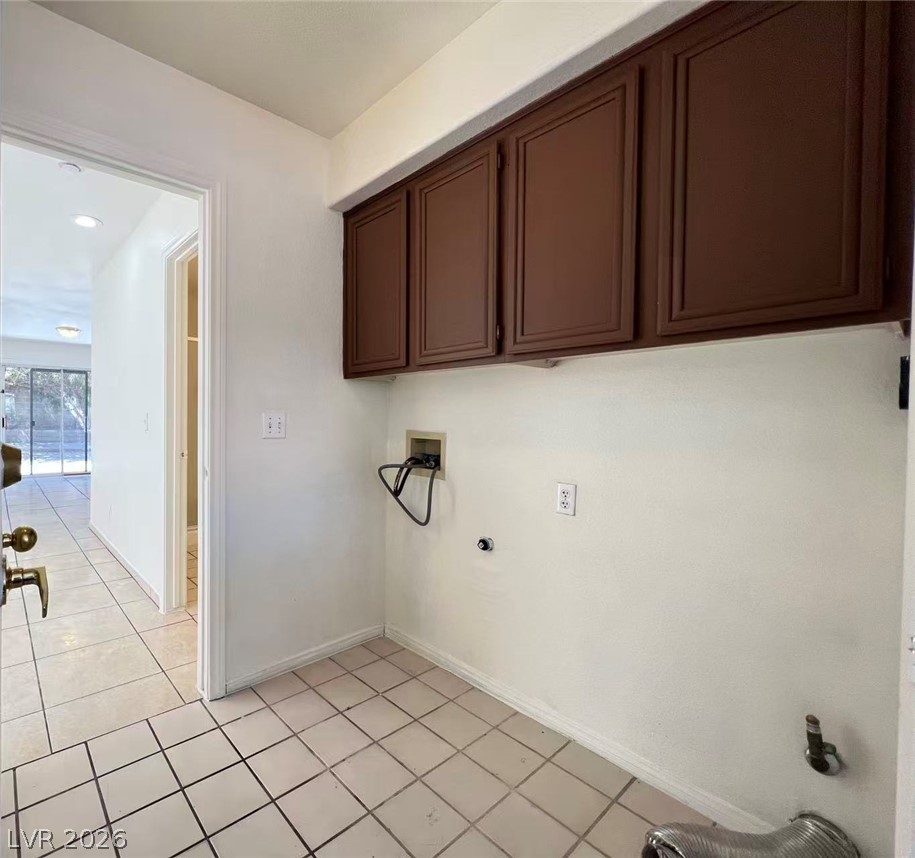 8284 West Rochelle Avenue Las Vegas, NV 89147 - Photo 11 of 29 Ample cabinetry provides storage above the well-lit laundry area with tile flooring.