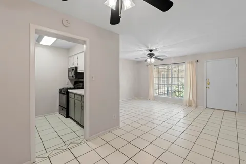 a view of an empty room with a kitchen