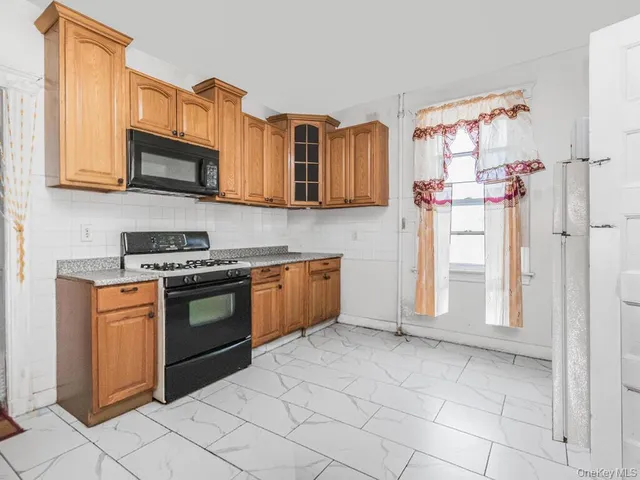 a kitchen with stainless steel appliances granite countertop a refrigerator and a stove top oven