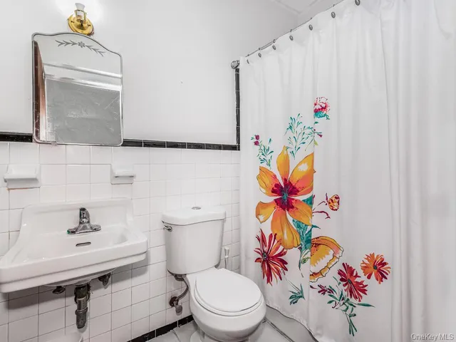 a bathroom with a sink vanity mirror and toilet