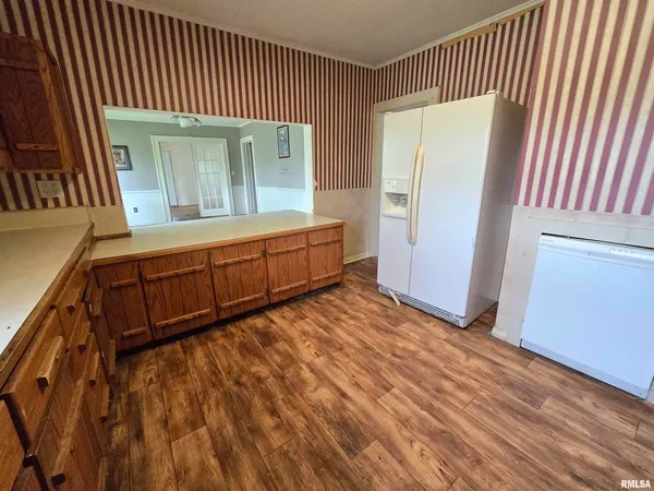 a kitchen with stainless steel appliances granite countertop a stove a sink dishwasher and a refrigerator with wooden floor