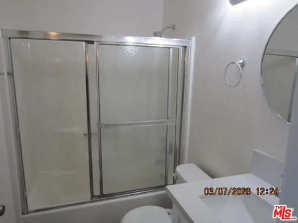 a bathroom with a shower a toilet and sink