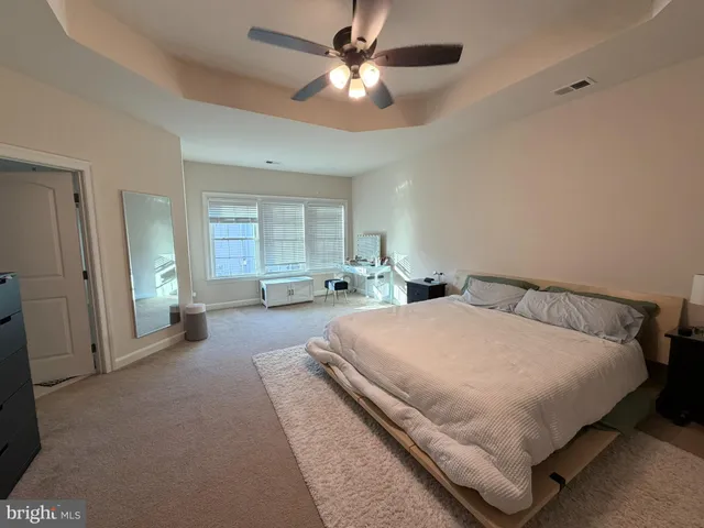a spacious bedroom with a bed and large windows