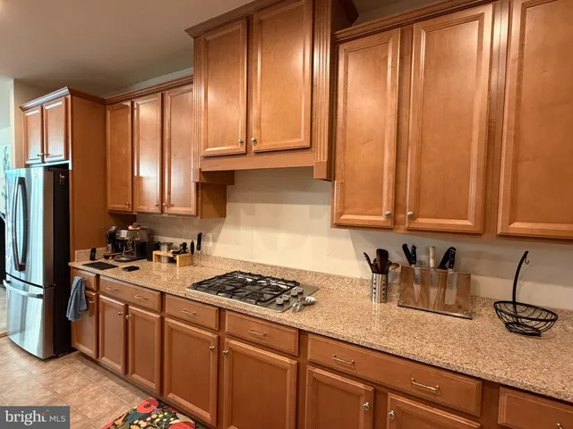a kitchen with kitchen island a sink stainless steel appliances and view living room