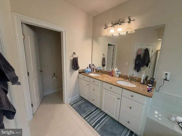 a spacious bathroom with a double vanity sink and a mirror