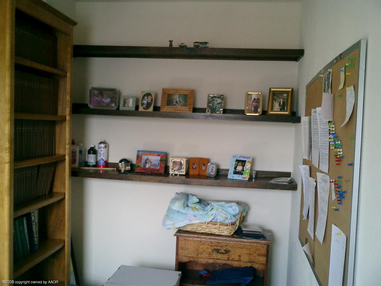 4319 South Hayden Street Amarillo, TX 79110 - Photo 8 of 13 a shelf with books and knick knacks on it